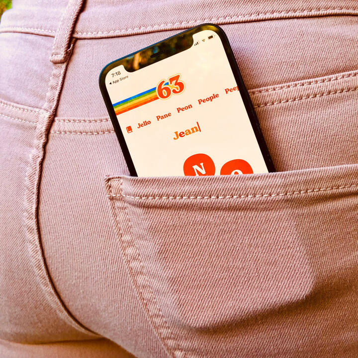 iPhone in jeans back pocket with Retrogram game screen displayed